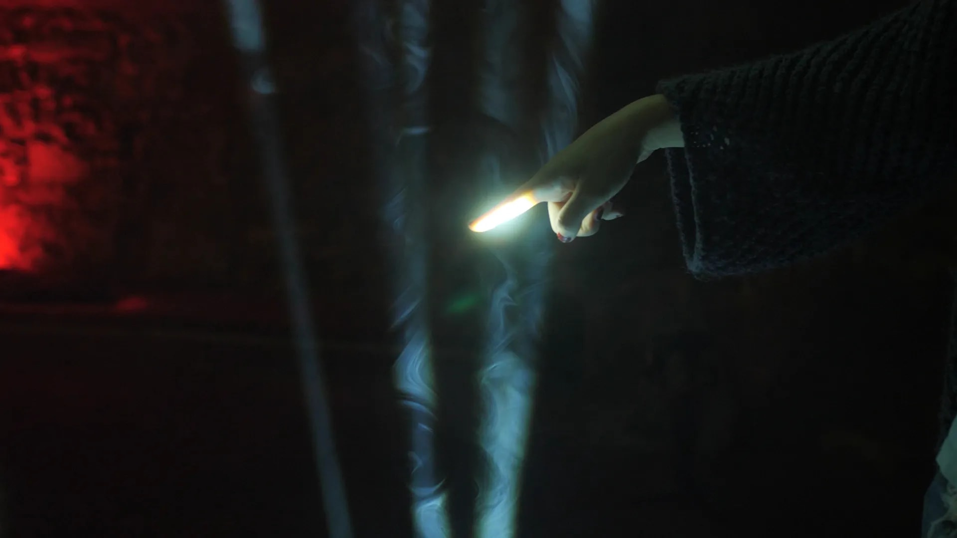 Ein Finger unterbricht einen Lichtstrahl der Installation Play the Light und löst damit einen Klang aus