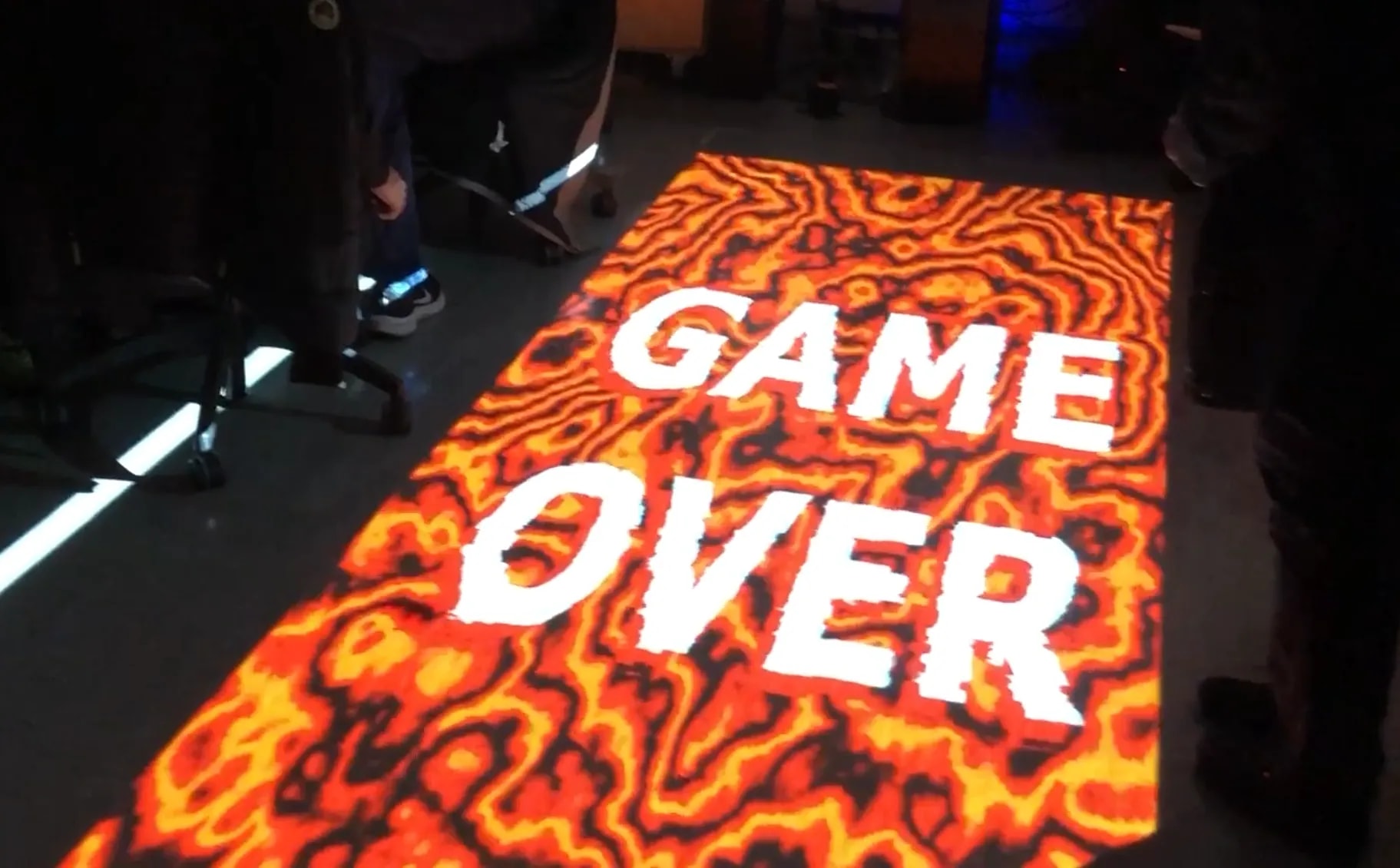Endbildschirm der interaktiven Bodenprojektion „The Floor Is Lava“ mit der Anzeige „Game Over“.