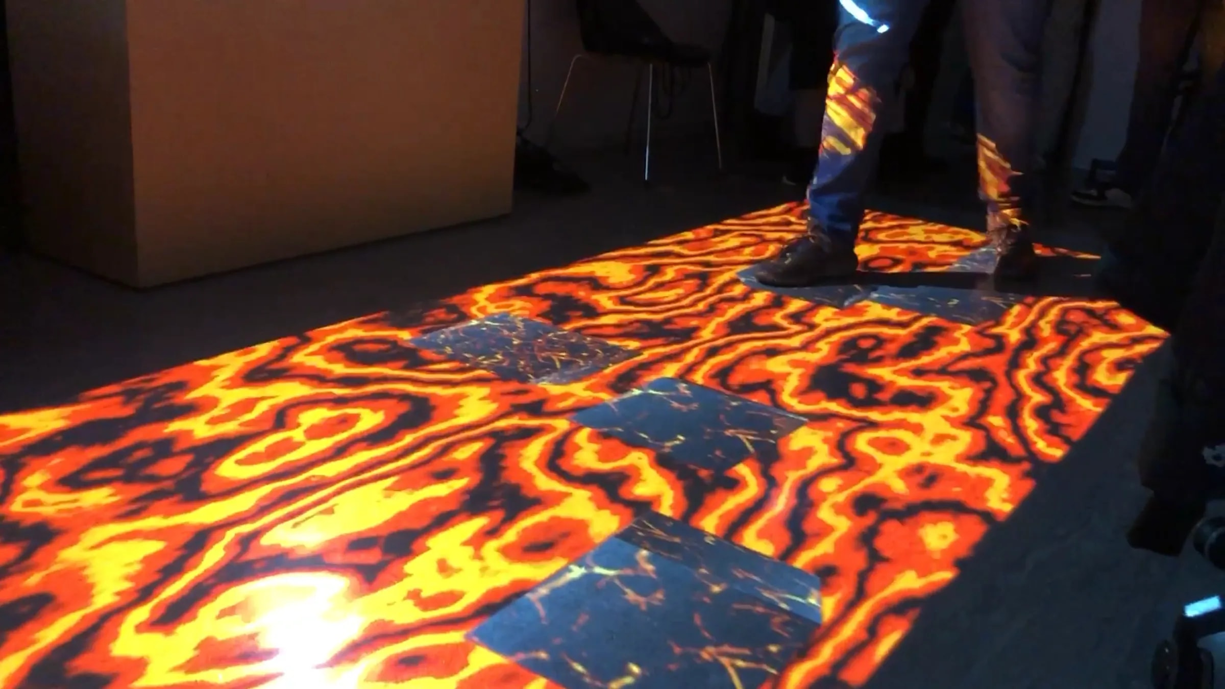 Interaktive Bodenprojektion „The Floor Is Lava“, bei der Besucher über sichere Plattformen navigieren und die Lava meiden müssen.