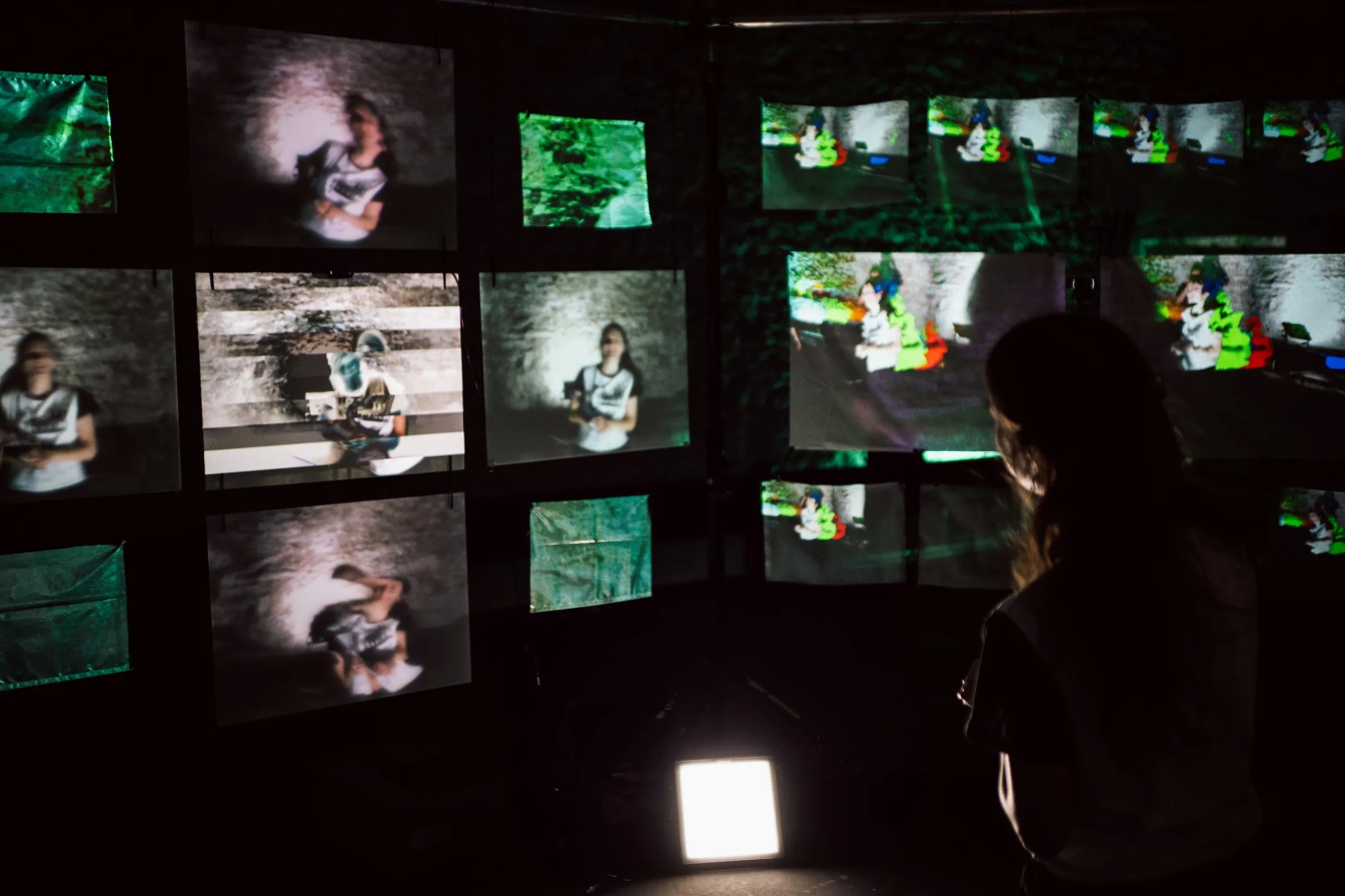 Besuchende betrachten die interaktive audiovisuelle Installation mit mehreren Projektionsflächen und Echtzeitprojektionen.