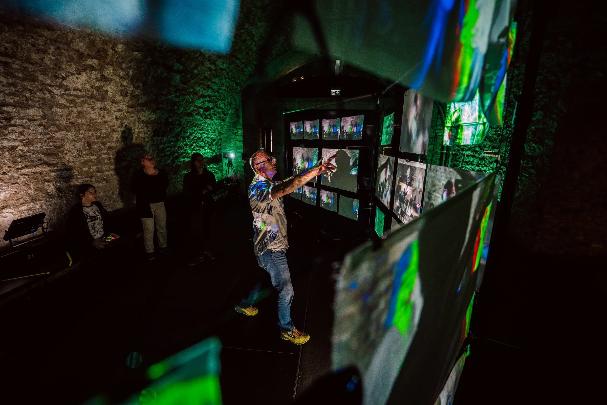 Gesamtansicht der Ausstellung „Echoes from Beyond“ mit Besuchenden und den 29 Projektionsflächen in der Kulturei Mainz.