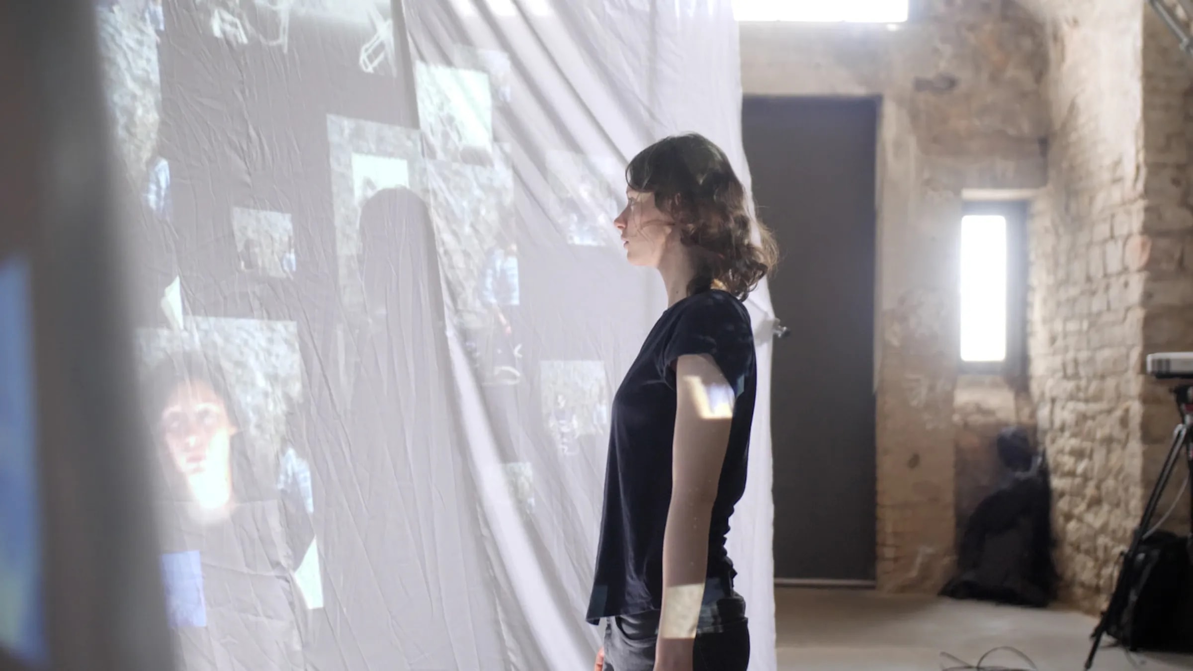 Eine Person steht vor den Projektionsflächen während eines Testaufbaus der interaktiven Installation „Echoes from Beyond“.